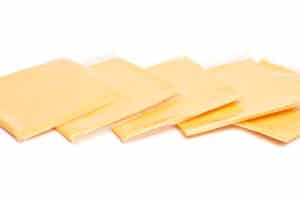 Five individually plastic-wrapped slices of yellow cheese fanned out on a white background.